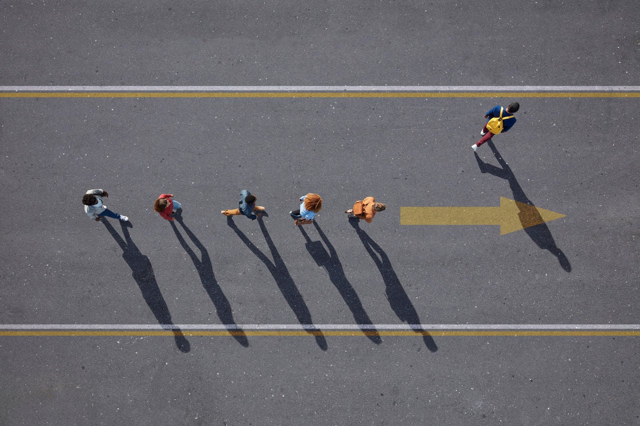 Group of young adults, photographed from above, on various painted tarmac surface, at sunrise.