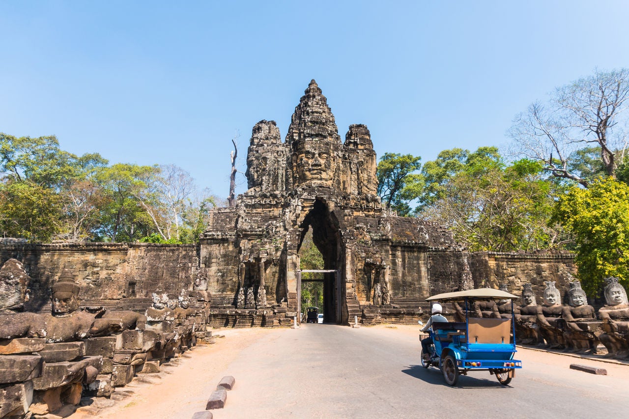 Tuk tuk and angkor thom gate in siem reap cambodia